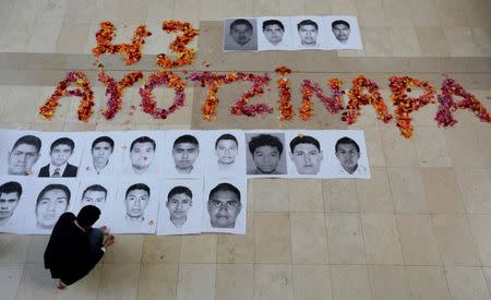 Portraits of some of the 43 missing students of the Ayotzinapa teachers' training college Raul Isidro Burgos are placed on the floor as students take part in a protest in support of them outside the Mexican Embassy in Bogota November 7, 2014. REUTERS/John Vizcaino