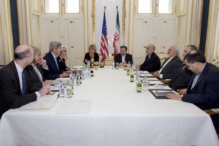 U.S. Secretary of State John Kerry (3rdL), flanked by National Security Council Senior Director for Iran, Iraq, Syria and the Gulf States Robert Malley (L), U.S. Energy Secretary Dr. Ernest Moniz (2ndL, Under Secretary of State for Political Affairs Wendy Sherman (4thL), and European Union Deputy Secretary General Helga Schmid, sits across from Iranian Foreign Minister Javad Zarif (3rdR); Iranian Vice President of Iran for Atomic Energy and President of the Atomic Energy Organization of Iran Dr. Ali Akbar Salehi (4thR) and other advisers at a hotel in Vienna, Austria June 30, 2015. REUTERS/State Department/Handout