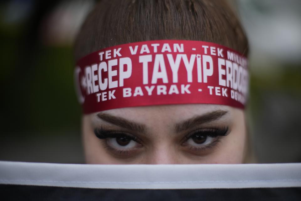 A supporter of President Recep Tayyip Erdogan stands outside the headquarters of AK Party in Istanbul, Turkey, Sunday, May 14, 2023. More than 64 million people, including 3.4 million overseas voters, were eligible to vote in the elections, which come the year the country will mark the centenary of its establishment as a republic — a modern, secular state born on the ashes of the Ottoman Empire. (AP Photo/Francisco Seco)