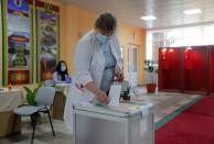 A voter casts a ballot at a polling station during the presidential election in Minsk