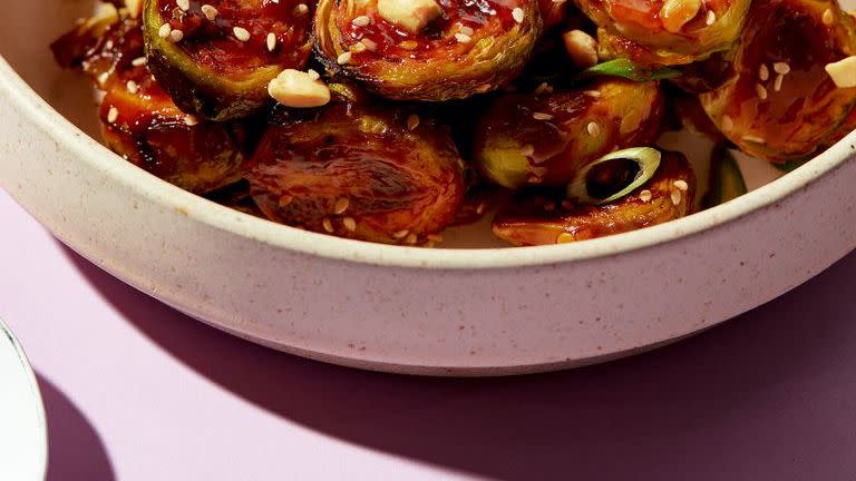 kung pao brussels topped with sesame seeds, peanuts, and scallions