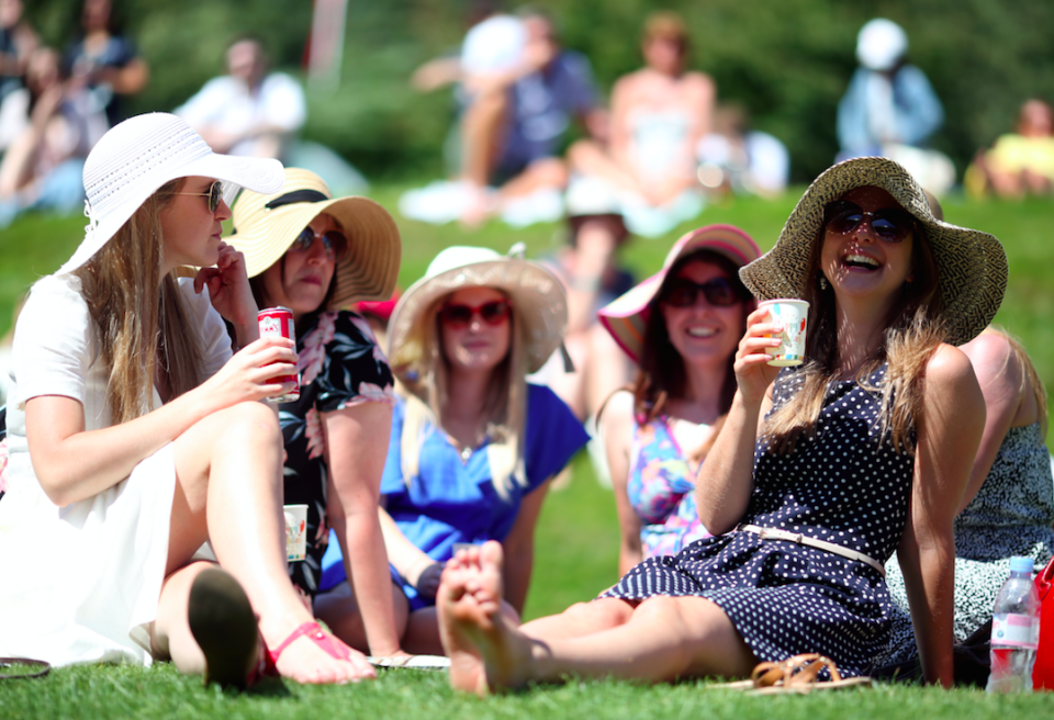 Tennis fans cool off on the lawns at the first day of Wimbledon on Monday (Picture: PA)