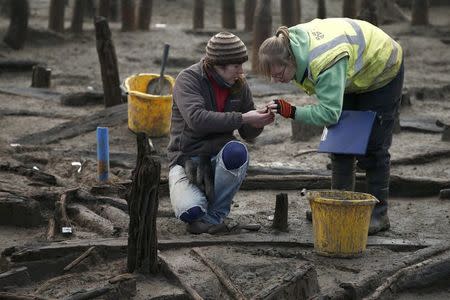 Archaeologists from the University of Cambridge Archaeological Unit, uncover Bronze Age wooden houses, preserved in silt, from a quarry near Peterborough, Britain, January 12, 2016. REUTERS/Peter Nicholls