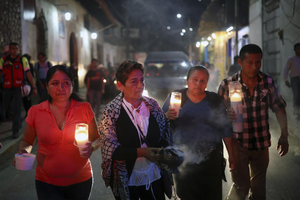 Mourners carry candles as they walk with the hearse bringing the body of Maricela Vallejo, the slain 27-year-old mayor of Mixtla de Altamirano, to her aunt's house for a wake in Zongolica, Veracruz state, Mexico, Thursday, April 25, 2019. Vallejo, her husband, and a driver were assassinated Thursday by multiple gunmen as they drove along a highway. (AP Photo/Felix Marquez)