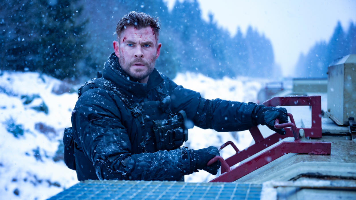  Chris Hemsworth looks worried, while hanging onto a train ladder, in Extraction 2. 