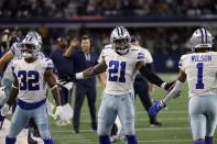 Dallas Cowboys' Corey Clement (32), Ezekiel Elliott (21) and Cedrick Wilson (1) celebrate late in the second half of an NFL football game against the Philadelphia Eagles in Arlington, Texas, Monday, Sept. 27, 2021. (AP Photo/Ron Jenkins)