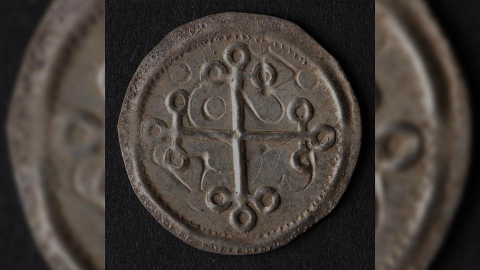 A prominent cross on one side of some of the Danish coins found suggests they were minted late in the reign of the powerful Danish king Harald Bluetooth, about A.D. 980. Here we see a close up of the cross side of the silver coin. On the end of each cross there are 3 small circles.