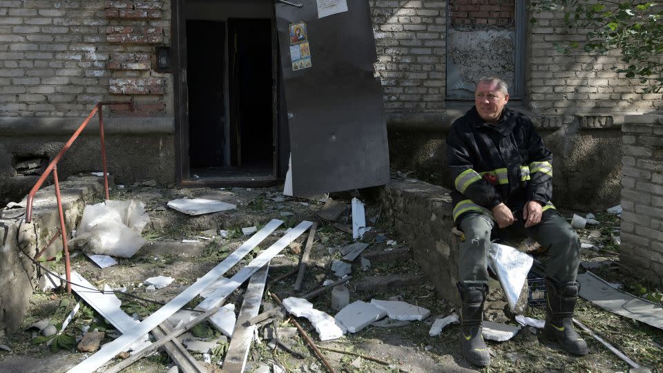 A rescuer rests next to a destroyed residential building in Luhansk. - AFP/Getty Images