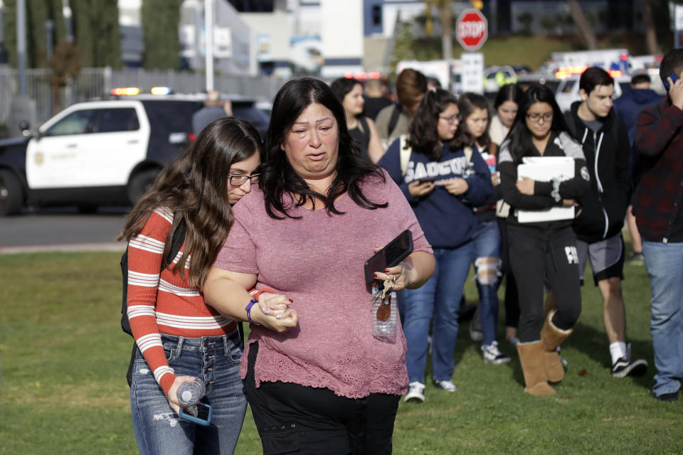 Students are escorted in a single file line as some parents pick them up outside of Saugus High School after reports of a shooting on Thursday, Nov. 14, 2019, in Santa Clarita, Calif. (AP Photo/Marcio Jose Sanchez)