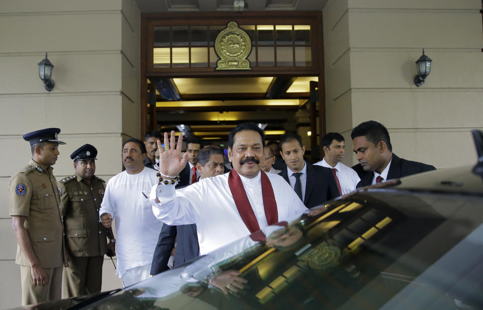 Sri Lankan prime minister Mahinda Rajapaksa waves to people after assuming duties as finance minister in Colombo, Sri Lanka, Wednesday, Oct. 31, 2018. President Maithripala Sirisena dismissed Ranil Wickremesinghe and his Cabinet on Friday and replaced him with former strongman Mahinda Rajapaksa. On Saturday, Sirisena suspended Parliament in an apparent move to give Rajapaksa time to muster enough support to survive any no-confidence vote. (AP Photo/Eranga Jayawardena)