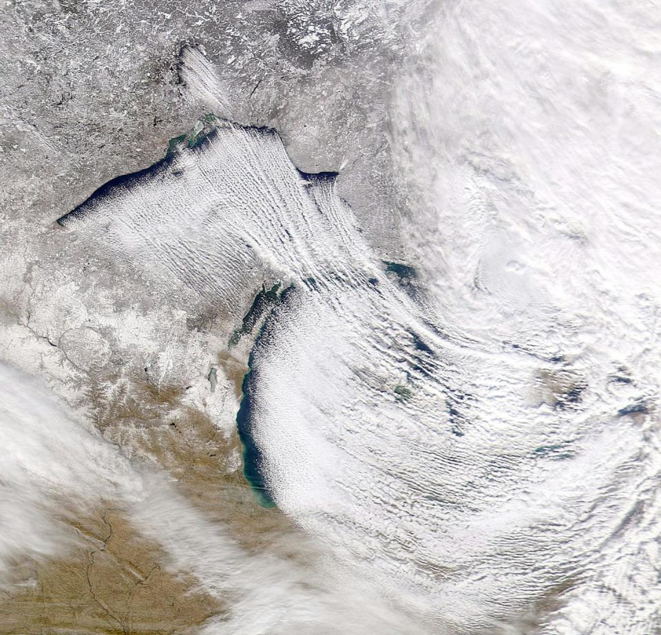 A satellite image shows open water on the western shores the Great Lakes and storms forming to dump snow on the eastern shores.