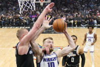 Sacramento Kings forward Domantas Sabonis, center, shoots as Los Angeles Clippers center Mason Plumlee, left, and guard Russell Westbrook defend during the first half of an NBA basketball game Friday, Feb. 24, 2023, in Los Angeles. (AP Photo/Mark J. Terrill)