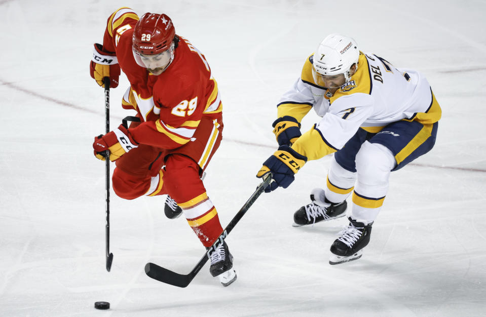 Nashville Predators defenseman Marc Del Gaizo, right, battles for the puck with Calgary Flames forward Dillon Dube (29) during the third period of an NHL hockey match in Calgary, Alberta, Tuesday, Nov. 7, 2023. (Jeff McIntosh/The Canadian Press via AP)