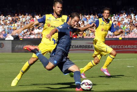 Napoli's Gonzalo Higuain (R) fights for the ball with Chievo Verona's Bostjan Cesar during their Serie A soccer match at San Paolo stadium in Naples, September 14, 2014. REUTERS/Ciro de Luca