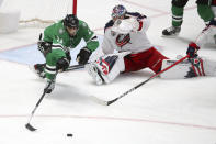 Dallas Stars center Andrew Cogliano (11) lunges for the puck after it was deflected by Columbus Blue Jackets goaltender Elvis Merzlikins (90) in the second period during an NHL hockey game on Thursday, April 15, 2021, in Dallas. (AP Photo/Richard W. Rodriguez)