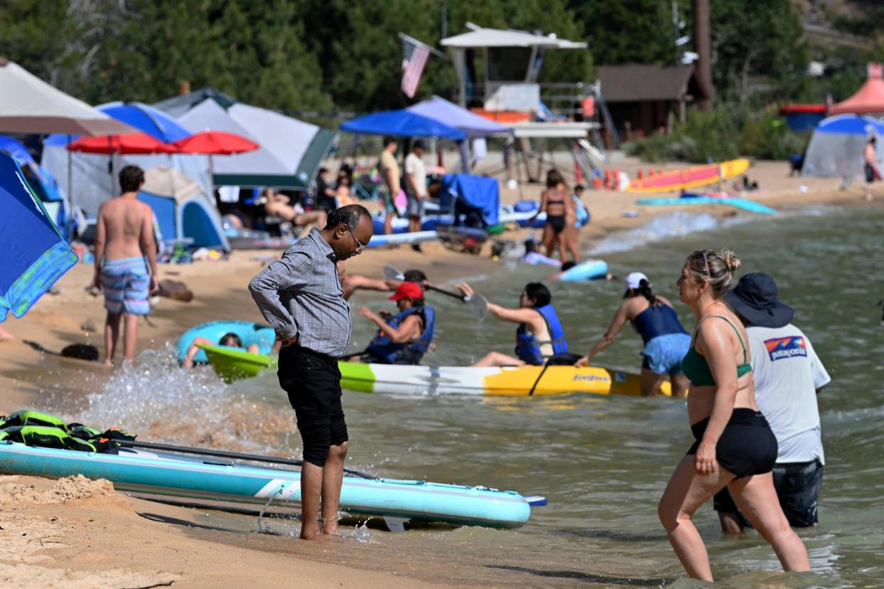 A man wets his feet in the cool water of Lake Tahoe at Lake Tahoe Nevada State Park in Incline Village, Nevada on July 17, 2023.