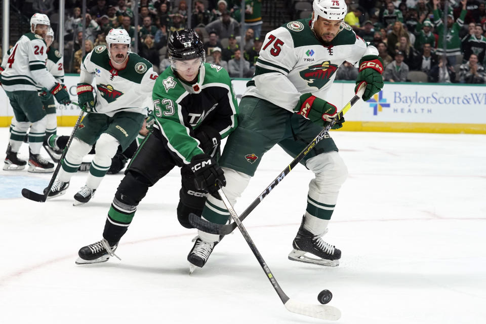 Minnesota Wild right wing Ryan Reaves (75) and Dallas Stars center Wyatt Johnston (53) skate for the puck during the first period of an NHL hockey game in Dallas, Sunday, Dec. 4, 2022. (AP Photo/LM Otero)