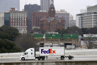 A driver in a FedEx truck drives on IH 35 North on icy and slushy road conditions, Wednesday, Feb. 1, 2023, in Dallas. (AP Photo/Tony Gutierrez)