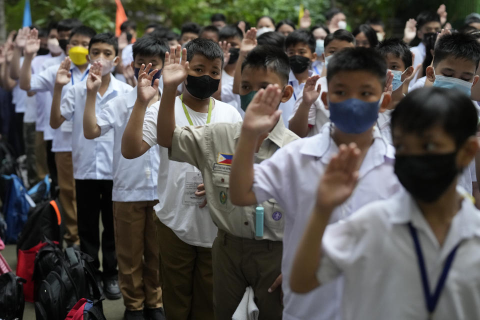 Students attend a flag raising ceremony during the opening of classes at the San Juan Elementary School in metro Manila, Philippines on Monday, Aug. 22, 2022. Millions of students wearing face masks streamed back to grade and high schools across the Philippines Monday in their first in-person classes after two years of coronavirus lockdowns that are feared to have worsened one of the world's most alarming illiteracy rates among children. (AP Photo/Aaron Favila)