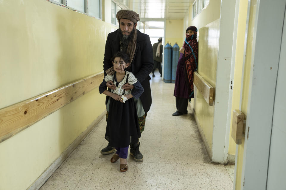 A girl walks with the help of her father in Indira Gandhi Children's Hospital in Kabul, Afghanistan, on Wednesday, Dec. 8, 2021. Since the chaotic Aug. 15 Taliban takeover of Kabul, an already war-devastated economy once kept alive by international donations alone is now on the verge of collapse. There isn't enough money for hospitals. The World Health Organization is warning of millions of children suffering malnutrition, and the U.N. says 97% of Afghans will soon be living below the poverty line. (AP Photo/Petros Giannakouris)