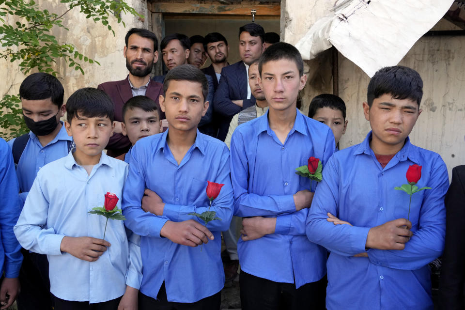 Afghan students hold rose on the first day of school after Tuesday's explosion in front of their school, in Kabul, Afghanistan, Saturday, April 23, 2022. On Saturday, the Abdul Rahim Shaheed School, which was among the IS-K targets in the Tuesday attacks, re-opened. The school's principal handed each student a pen and a flower as they began classes on Saturday. (AP Photo/Ebrahim Noroozi)