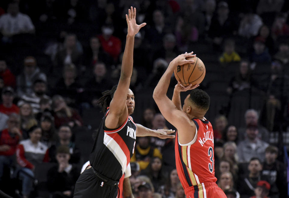 New Orleans Pelicans guard CJ McCollum, right, shoots over Portland Trail Blazers forward Jabari Walker during the first half of an NBA basketball game Saturday Feb. 10, 2024, in Portland, Ore. (AP Photo/Steve Dykes)