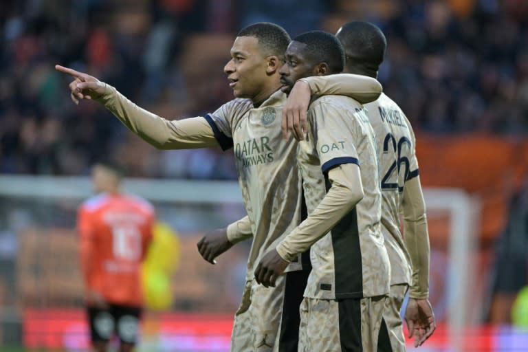 Los delanteros franceses del París SG Kylian Mbappé (izquierda) y Ousmane Dembele (centro) celebran la victoria de su equipo ante el Lorient en partido de Ligue 1 dispitado en el estadio Moustoir de Lorient, el 24 de abril de 2024 (DAMIEN MEYER)