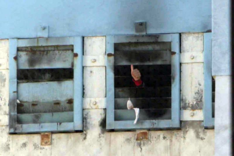 A prisoner signals "thumbs-up" after a fire spread through the San Miguel prison killing more than 80 people south of Santiago, Chile, on December 8, 2010. File Photo by Sebastian Padilla/UPI