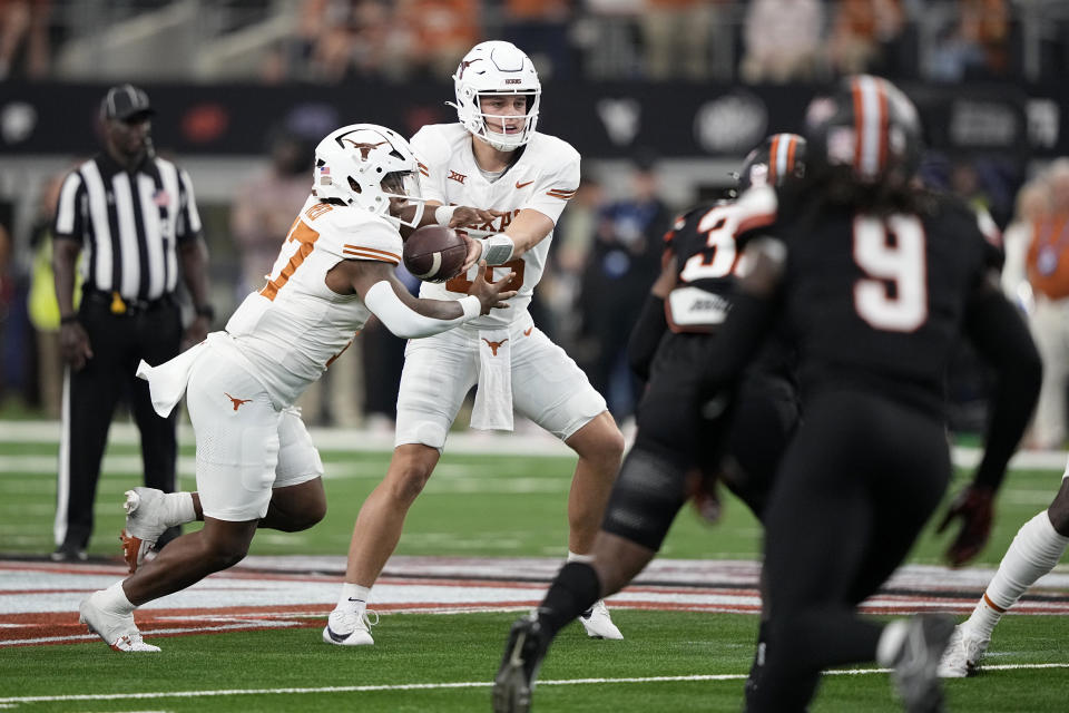 Texas quarterback Arch Manning (16) hands the ball off to running back Savion Red (17) during the second half of the Big 12 Conference championship NCAA college football game against Oklahoma State in Arlington, Texas, Saturday, Dec. 2, 2023. (AP Photo/Tony Gutierrez)