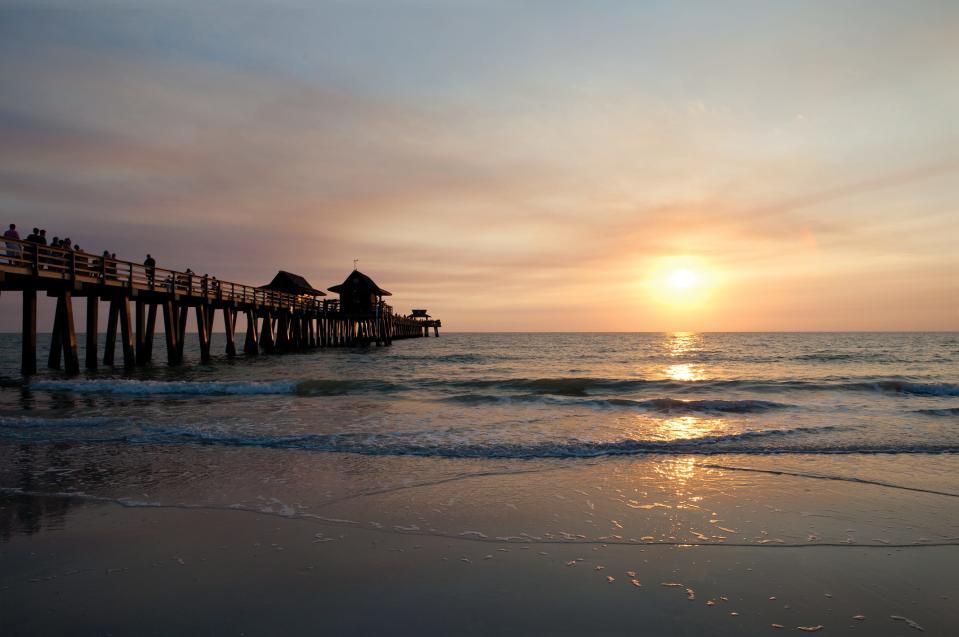 The sun sets over the Gulf of Mexico and Naples Pier, a free attraction for fishing, strolling or just relaxing.