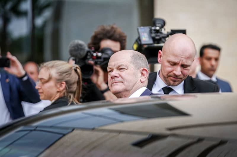 Germany's Chancellor Olaf Scholz (C) comes out of the hotel in Aqaba for the onward journey to Isreal. Kay Nietfeld/dpa