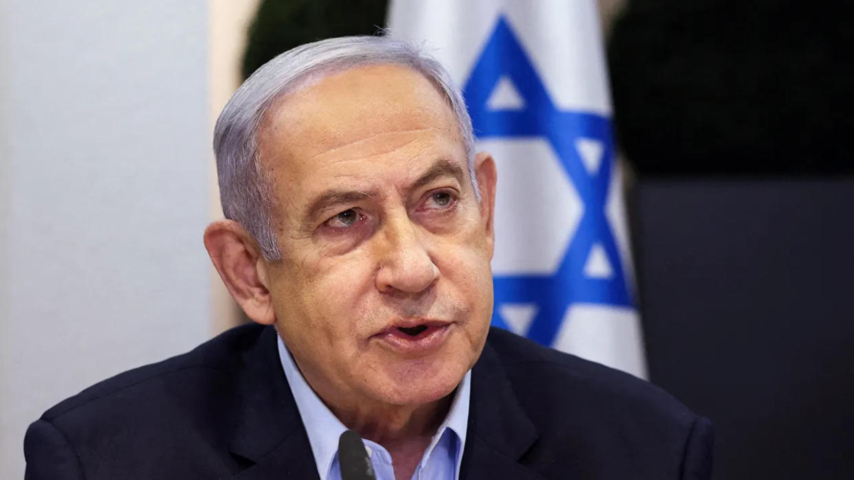 Benjamin Netanyahu in front of the flag of Israel