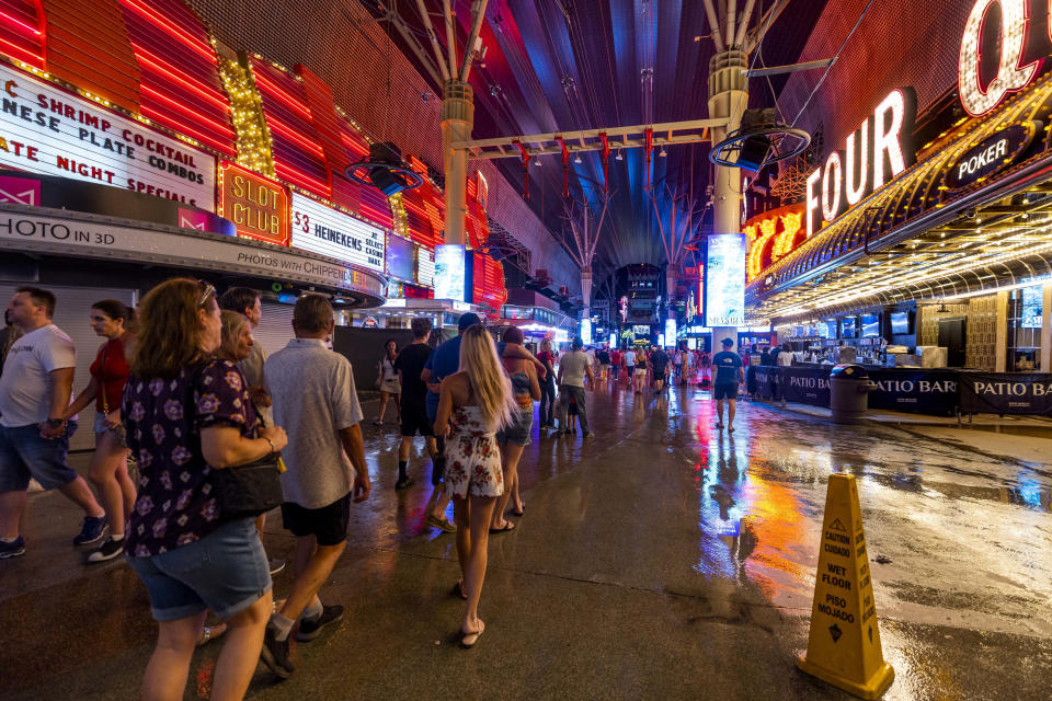 La gente circula por la Fremont Street Experience en medio de una fuerte tormenta en la zona, el jueves 28 de julio de 2022, en Las Vegas. (L.E. Baskow/Las Vegas Review-Journal vía AP)