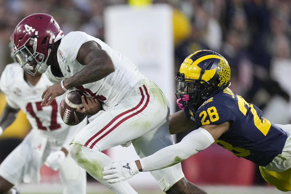 Alabama quarterback Jalen Milroe (4) fumbles as he is tackled by Michigan defensive back Quinten Johnson (28) during the second half in the Rose Bowl CFP NCAA semifinal college football game Monday, Jan. 1, 2024, in Pasadena, Calif. Michigan recovered the ball on the play. (AP Photo/Mark J. Terrill)