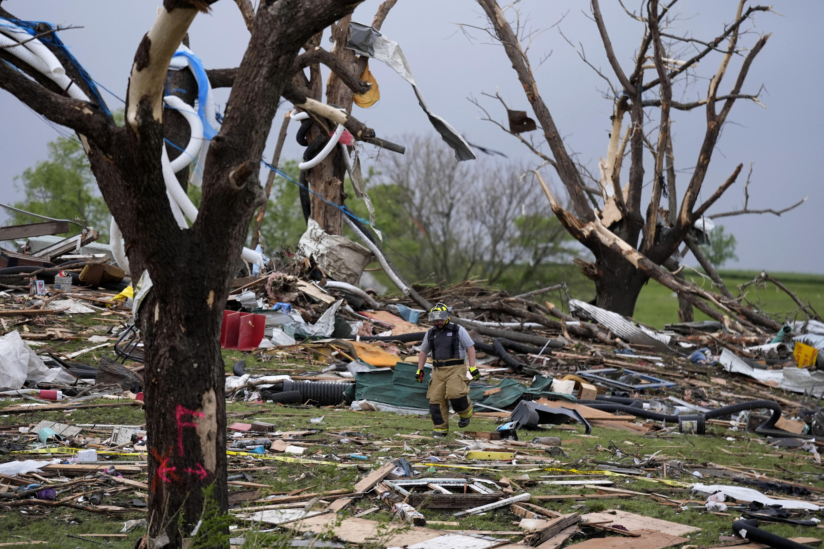 A firefighter walks among tornado-damaged homes on Tuesday in Greenfield, Iowa.