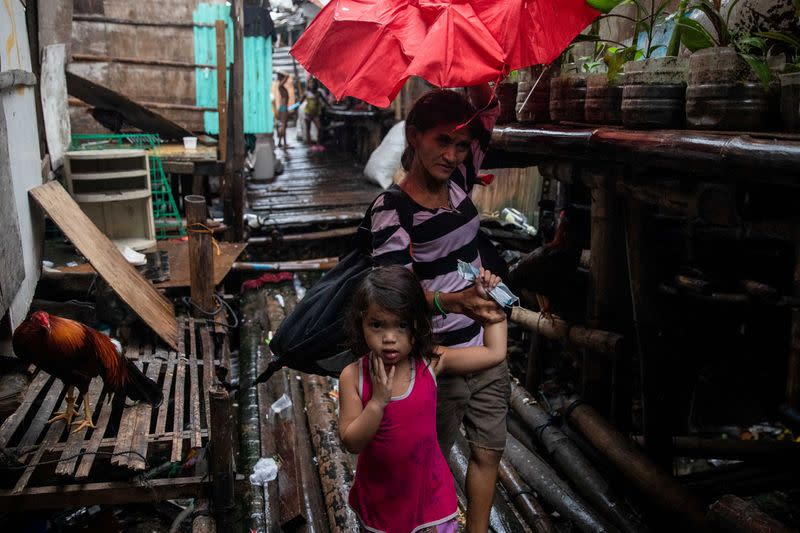 Residents in a coastal community in Metro Manila evacuate ahead of Typhoon Vamco