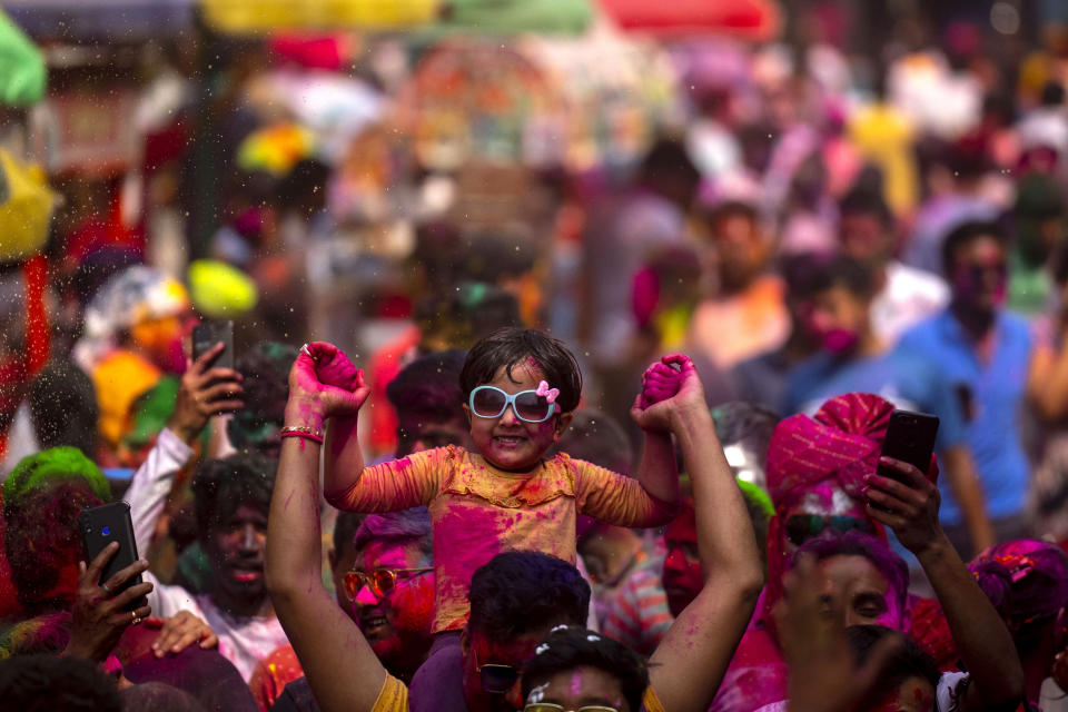 People celebrate Holi, the festival of colors on a street in Guwahati, India, Wednesday, March 8, 2023.Millions of Indians on Wednesday celebrated the ''Holi" festival, dancing to the beat of drums and smearing each other with green, yellow and red colors and exchanging sweets in homes, parks and streets. Free from mask and other COVID-19 restrictions after two years, they also drenched each other with colored water. (AP Photo/Anupam Nath)