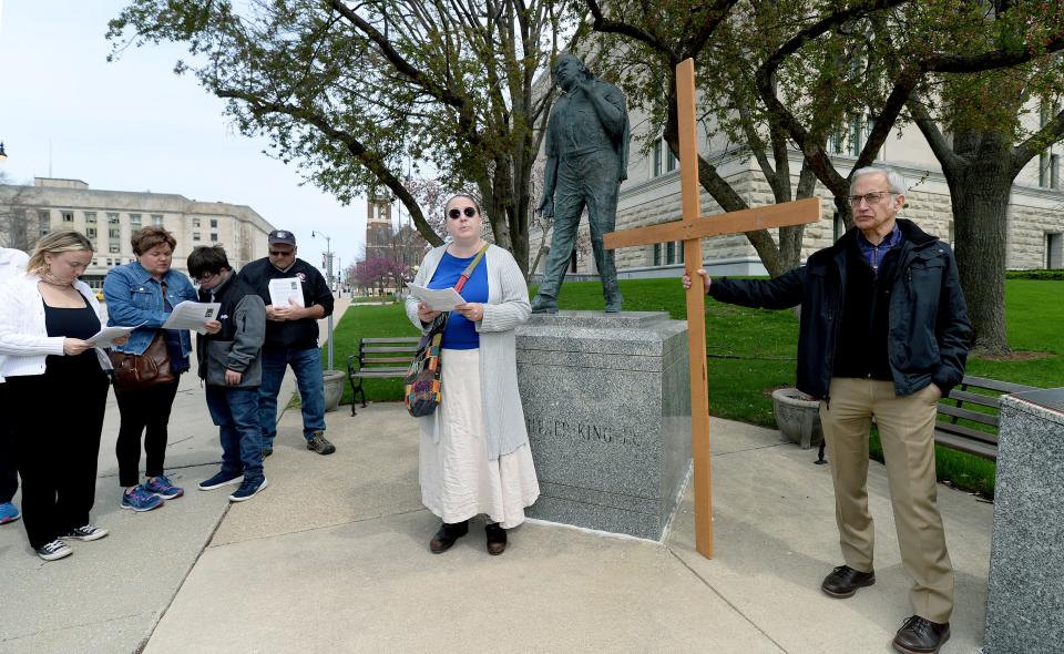 The Rev. Dr. Bobbi Dykema, pastor at First Church of the Brethren in Springfield, center, reads the second station of the cross in front of the Martin Luther King Jr. statue at Fourth and Capitol during the Good Friday Way of the Cross in Springfield in 2022.