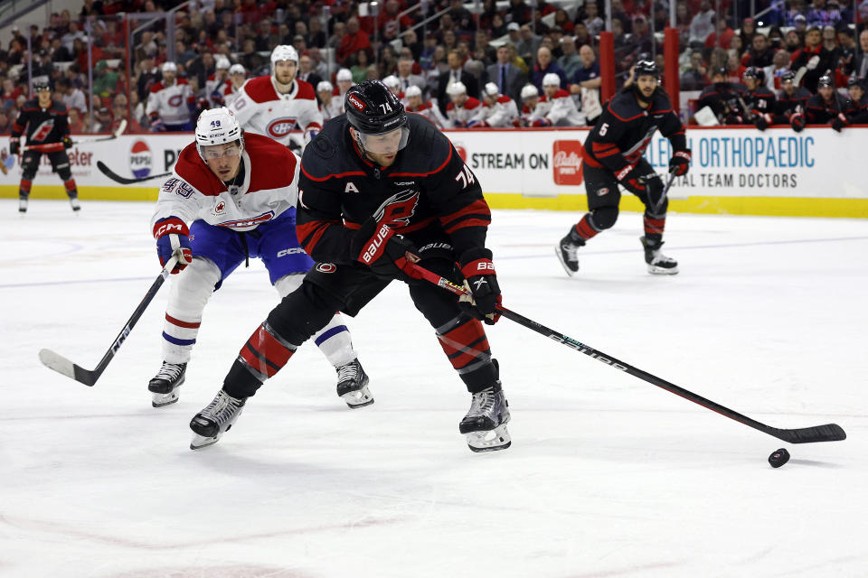 Carolina Hurricanes' Jaccob Slavin (74) controls the puck in front of Montreal Canadiens' Rafael Harvey-Pinard (49) during the first period of an NHL hockey game in Raleigh, N.C., Thursday, March 7, 2024. (AP Photo/Karl B DeBlaker)