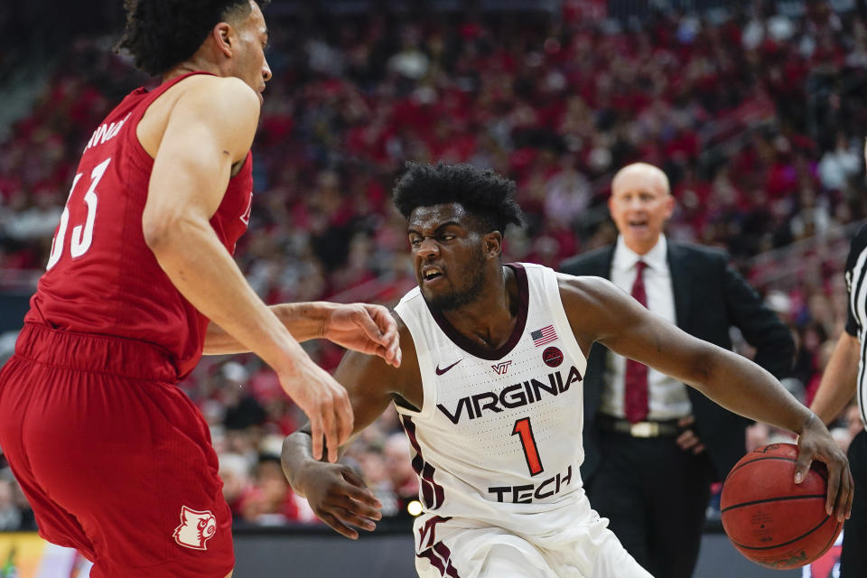 Virginia Tech guard Isaiah Wilkins (1) dribbles around Louisville forward Jordan Nwora (33) during the first half of an NCAA college basketball game, Sunday, March 1, 2020, in Louisville, Ky. (AP Photo/Bryan Woolston)