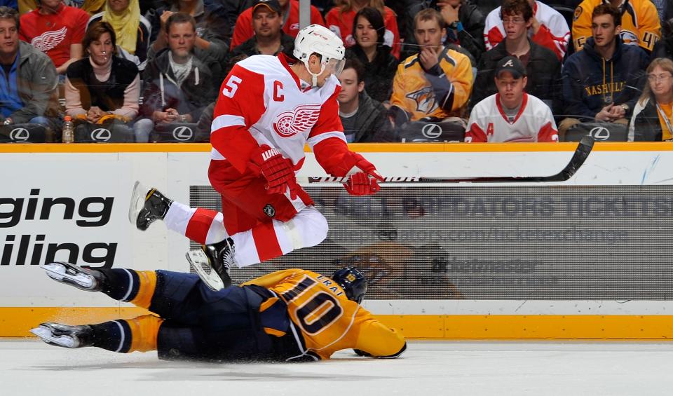 NASHVILLE, TN - DECEMBER 15: Nicklas Lidstrom #5 of the Detroit Red Wings jumps over Martin Erat #10 of the Nashville Predators at the Bridgestone Arena on December 15, 2011 in Nashville, Tennessee. (Photo by Frederick Breedon/Getty Images)