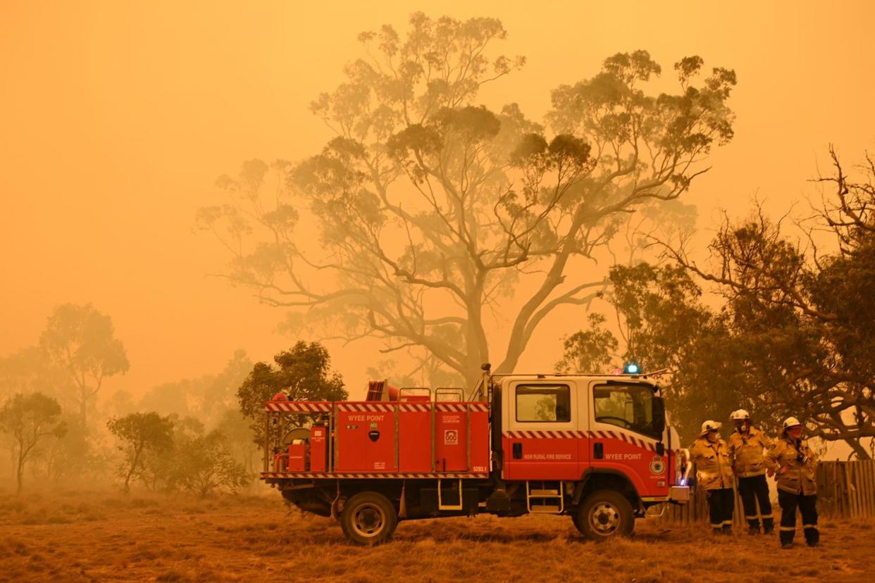 Firefighters protect a property from bushfires burning near the town of Bumbalong south of Canberra: Getty Images