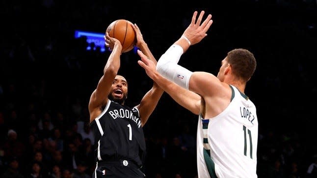 Brooklyn Nets forward Mikal Bridges (1) shoots over Milwaukee Bucks center Brook Lopez (11) during the first half of an NBA basketball game, Monday, Nov. 6, 2023, in New York. (AP Photo/Noah K. Murray)