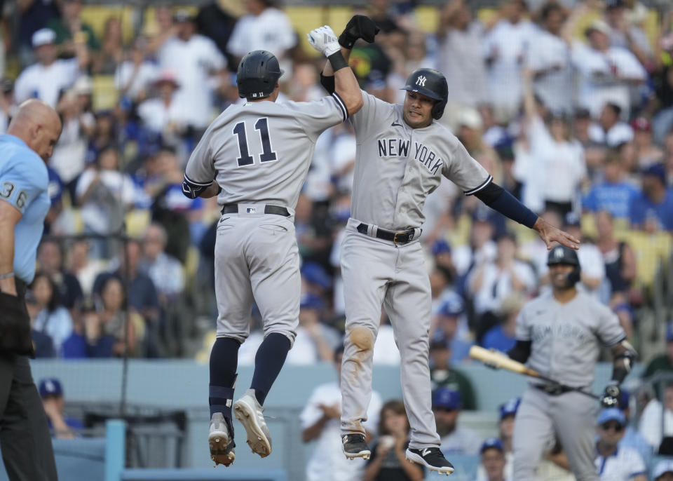 New York Yankees' Anthony Volpe (11) celebrates with Isiah Kiner-Falefa (12) after they both scored off of a home run hit by Volpe during the ninth inning of a baseball game against the Los Angeles Dodgers in Los Angeles, Sunday, June 4, 2023. (AP Photo/Ashley Landis)
