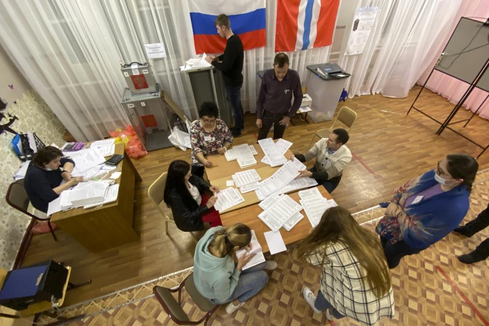 Members of an election commission prepare to count ballots after voting at a polling station after the Parliamentary elections in Nikolayevka village outside Omsk, Russia, Sunday, Sept. 19, 2021. From the Baltic Sea to the Pacific Ocean, Russians across eleven time zones voted Sunday on the third and final day of a national election for a new parliament, a ballot in which the pro-Kremlin ruling party is largely expected to retain its majority after months of relentless crackdown on the opposition. (AP Photo/Evgeniy Sofiychuk)