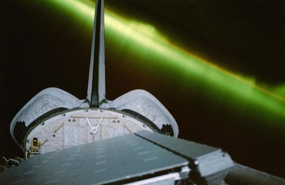 A greenish appearing aurora forms the backdrop for this 35mm scene of the Earth orbiting Space Shuttle Endeavour's aft cargo bay. Featured in the bay are the antennae for the SIR-C/X-SAR imaging radar instruments, illuminated by moonlight. The crew sighted the southern lights (aurora australis) several times during each of the eleven days of the mission. Image: NASA