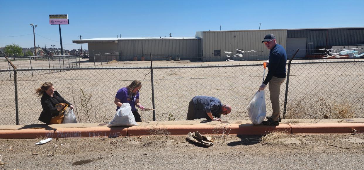 Volunteers with Keep Amarillo Clean clean up area outside the closed United Artists movie theatre Monday near Amarillo Boulevard in West Amarillo.