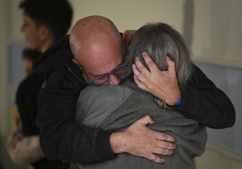 Sharon Hertzman, right, hugging her husband Hen Avigdori as they reunite at Sheba Medical Center in Ramat Gan, Israel on 25 November