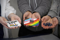 West Virginia University students El Didden, Bri Caison and Lia Farrell hold materials from the Rainbow Coats on Wednesday, March 8, 2023, in Morgantown, W.Va. (AP Photo/Kathleen Batten)