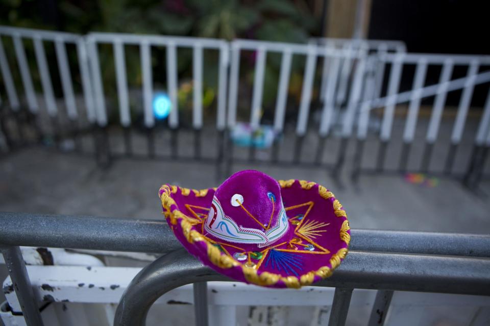 A Mexican tourist souvenir placed by a well-wisher sits on barriers blocking the entrance to the Blue Parrot club, where several people were killed in early morning gunfire, in Playa del Carmen, Mexico, Monday, Jan. 16, 2017. Deadly gunfire broke out in the crowded beachfront nightclub throbbing with electronic music before dawn on Monday, setting off a bloody stamped by screaming concertgoers at an international festival in this Caribbean resort.(AP Photo/Rebecca Blackwell)